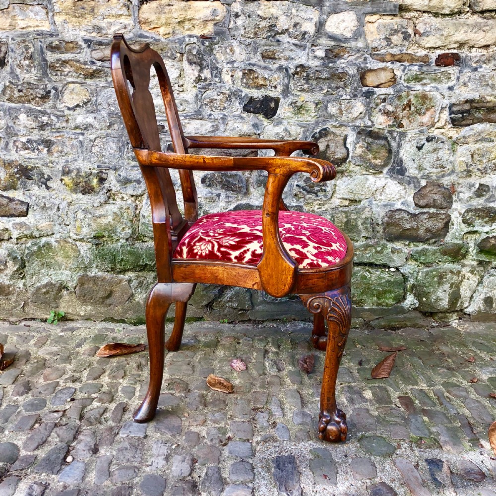 A George II style walnut armchair featuring a shaped splat back, carved cabriole legs with ball-and-claw feet, and a red patterned velvet seat. View II