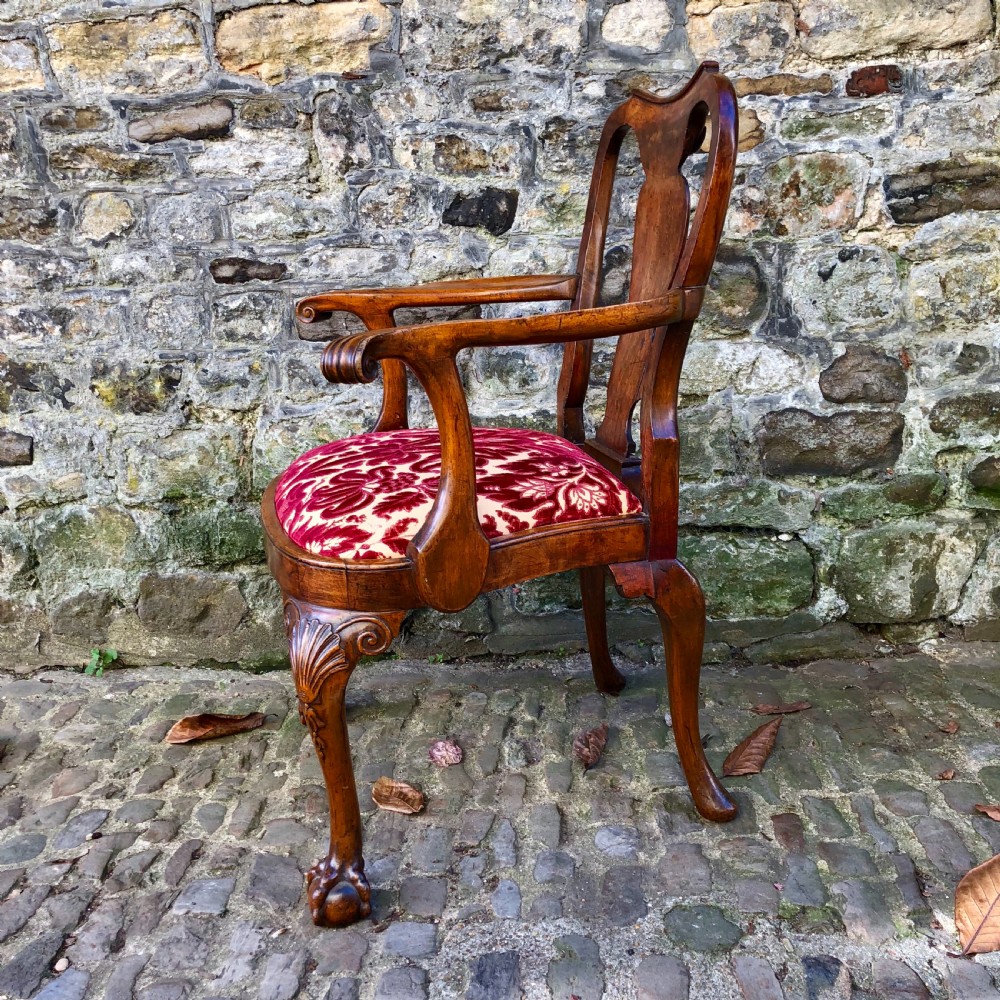 A George II style walnut armchair featuring a shaped splat back, carved cabriole legs with ball-and-claw feet, and a red patterned velvet seat. View III