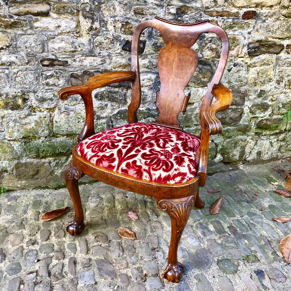 A George II style walnut armchair featuring a shaped splat back, carved cabriole legs with ball-and-claw feet, and a red patterned velvet seat. View IV