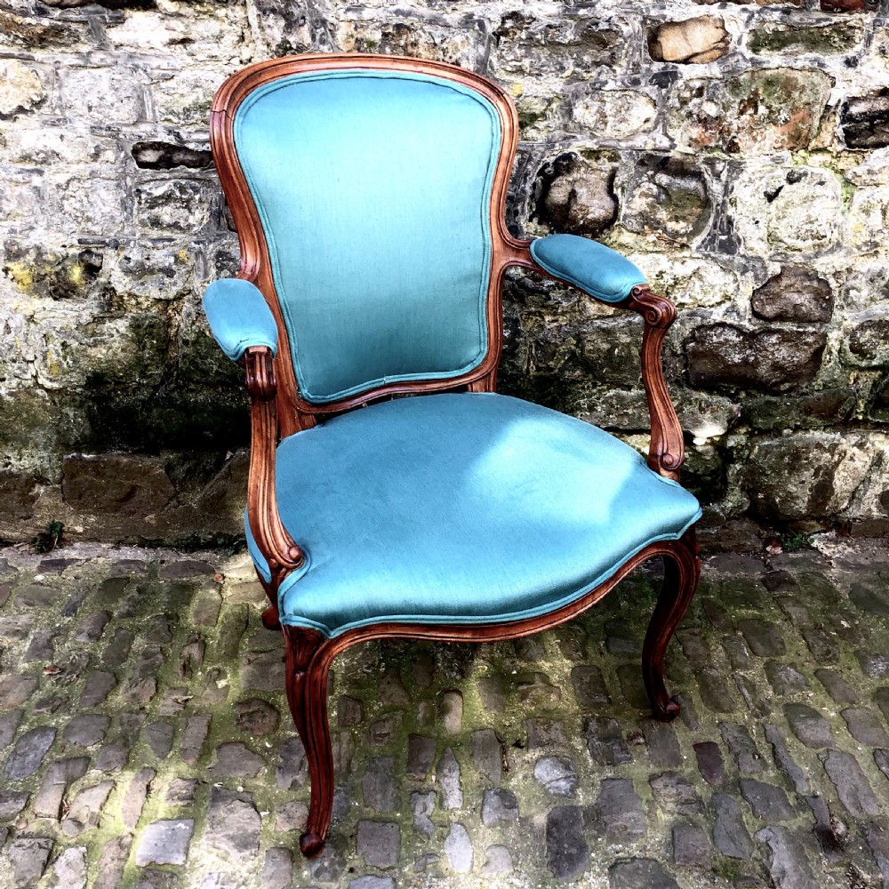 A Louis XV style open armchair crafted with a carved wooden frame, cabriole legs, and vibrant blue silk upholstery on the seat, backrest, and padded armrests. View II