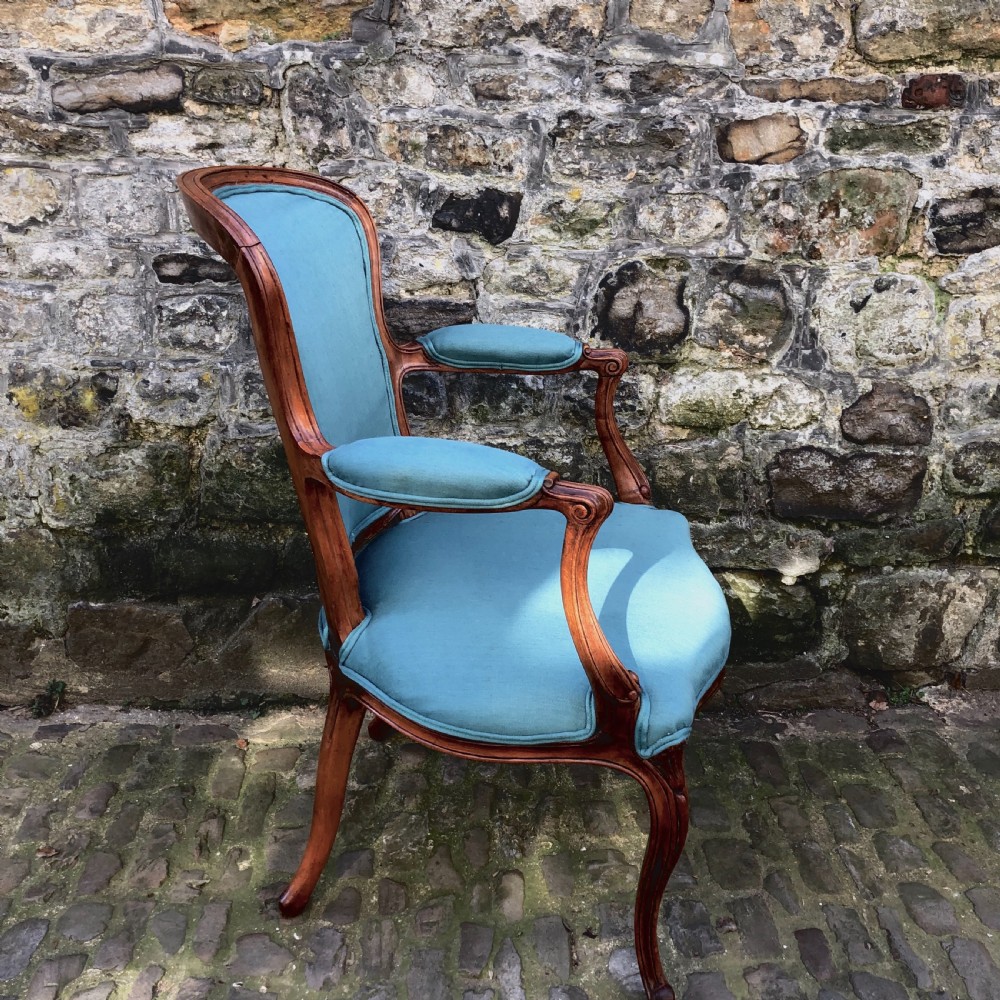 A Louis XV style open armchair crafted with a carved wooden frame, cabriole legs, and vibrant blue silk upholstery on the seat, backrest, and padded armrests. View III