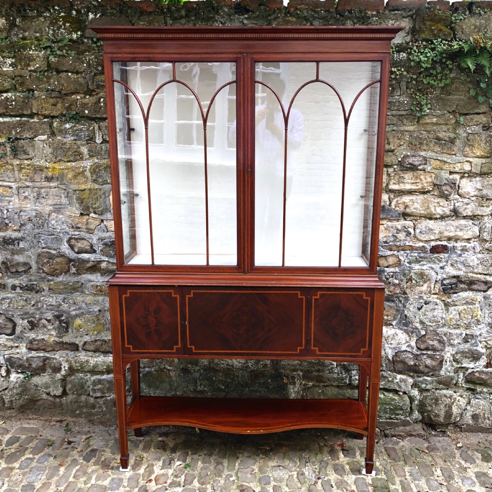 An Edwardian mahogany display cabinet on stand by Maples. 