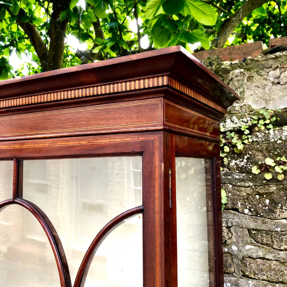 An Edwardian mahogany display cabinet on stand by Maples.  View IV