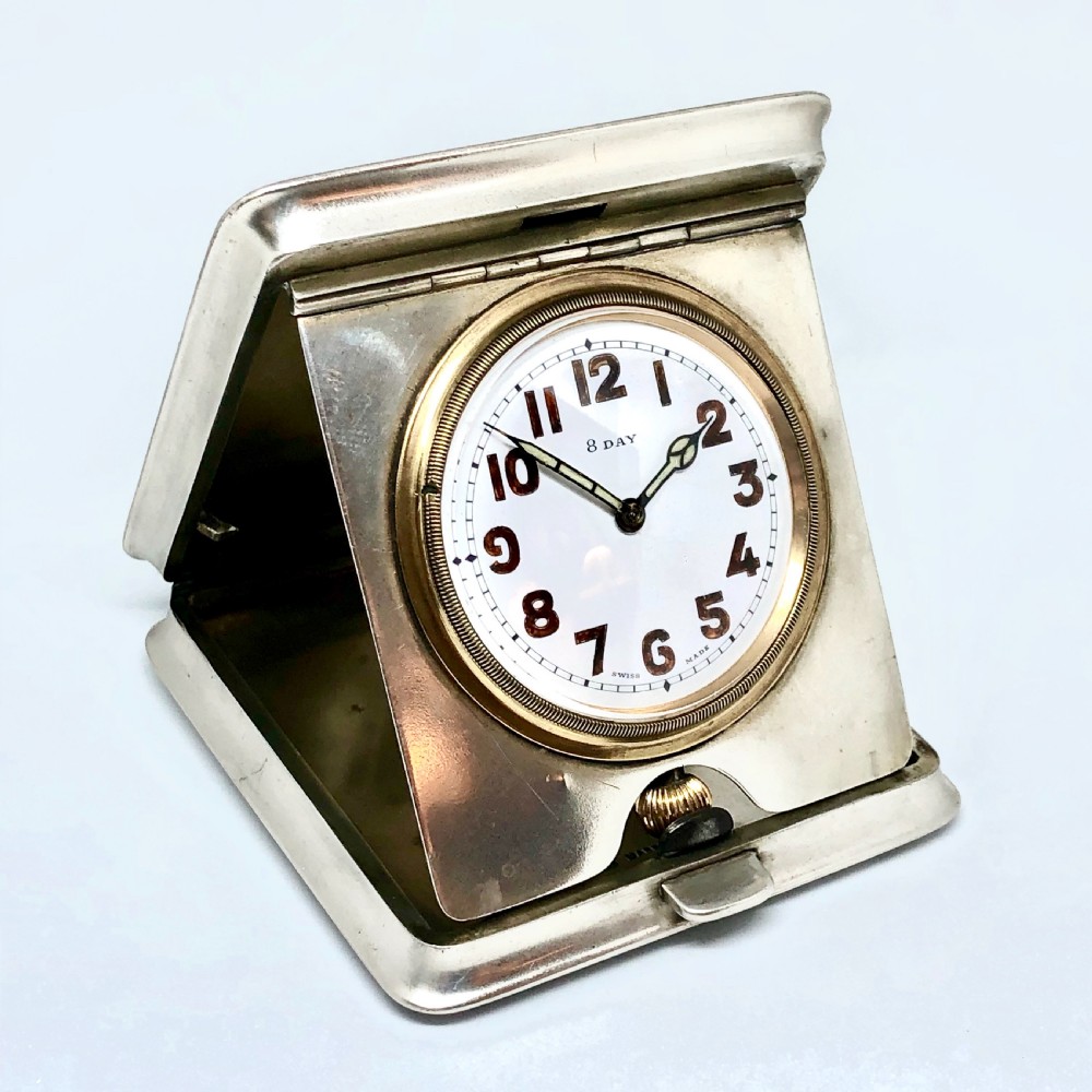 An early 20th-century silver folding travel clock by Mappin and Webb, featuring a square metallic case with a circular white dial and dark Arabic numerals. View II