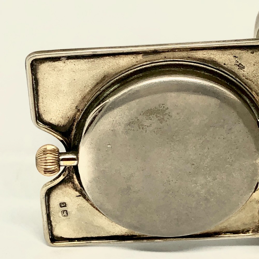 An early 20th-century silver folding travel clock by Mappin and Webb, featuring a square metallic case with a circular white dial and dark Arabic numerals. View V