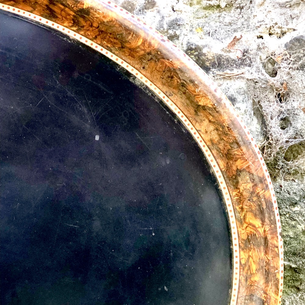 A mid-nineteenth century oval tole peinte tray featuring a black lacquered centre framed by a faux tortoiseshell rim with gilt detail. View III