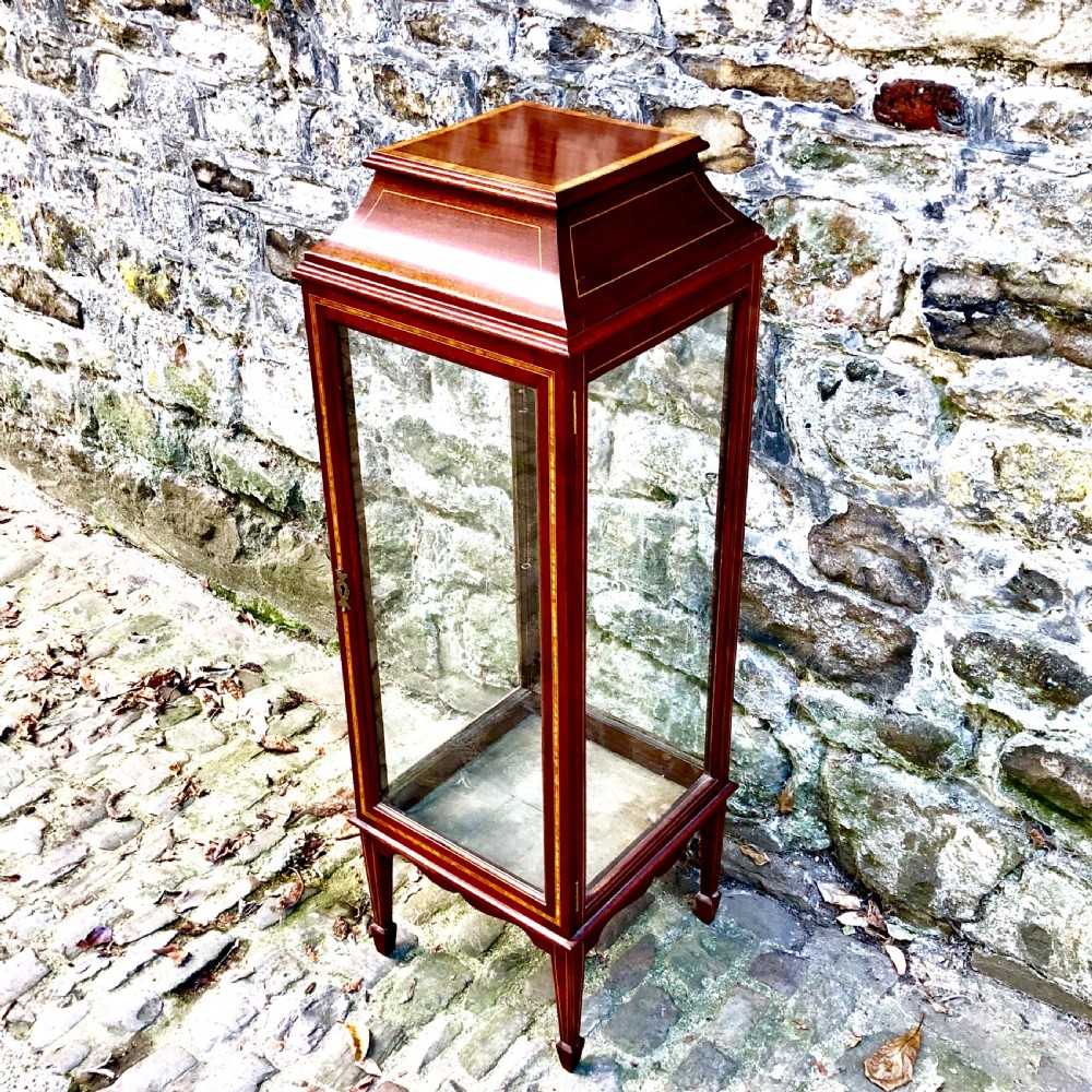 A tall, narrow Edwardian mahogany display cabinet with glazed side panels, fine wood stringing inlay, a single glass front door with a brass keyhole, and square tapered legs. View II