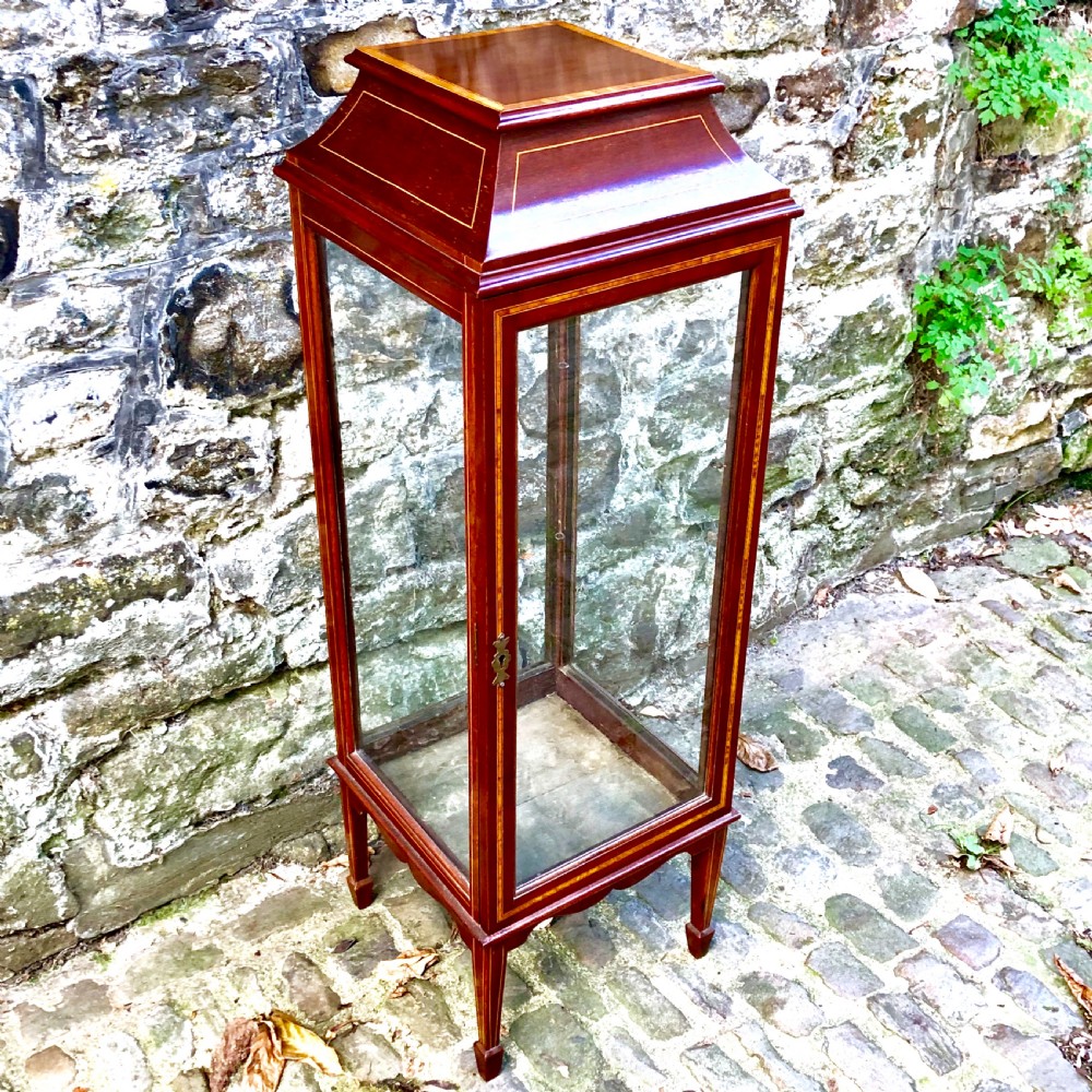 A tall, narrow Edwardian mahogany display cabinet with glazed side panels, fine wood stringing inlay, a single glass front door with a brass keyhole, and square tapered legs. View III