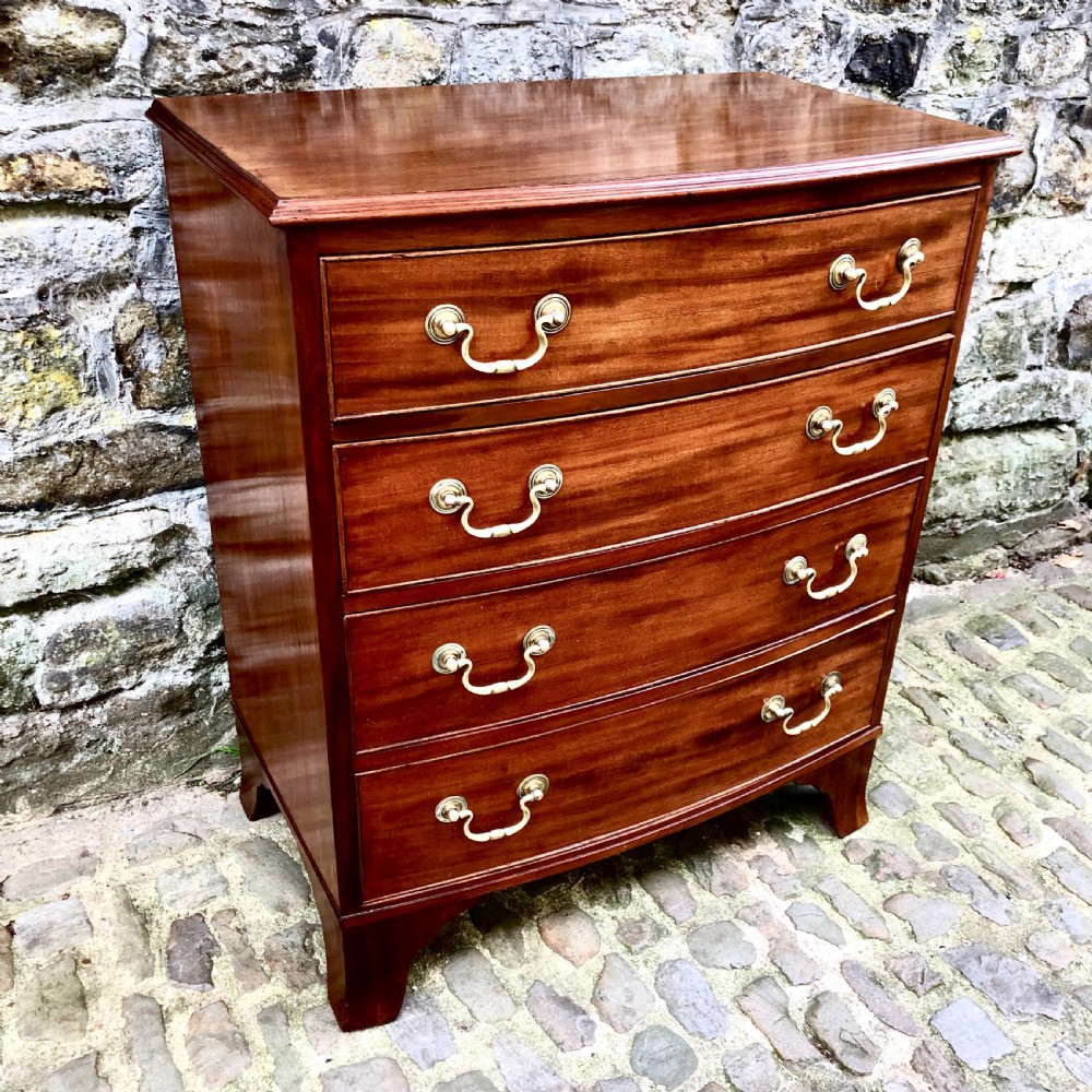 A mid-Victorian mahogany bowfront chest of drawers featuring four graduated drawers with curved fronts, brass drop handles, and bracket feet.