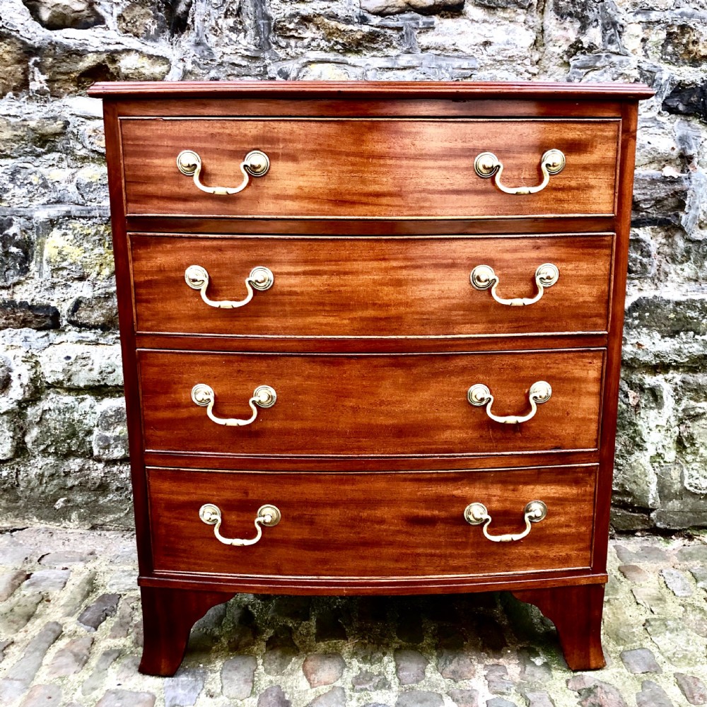 A mid-Victorian mahogany bowfront chest of drawers featuring four graduated drawers with curved fronts, brass drop handles, and bracket feet. View II