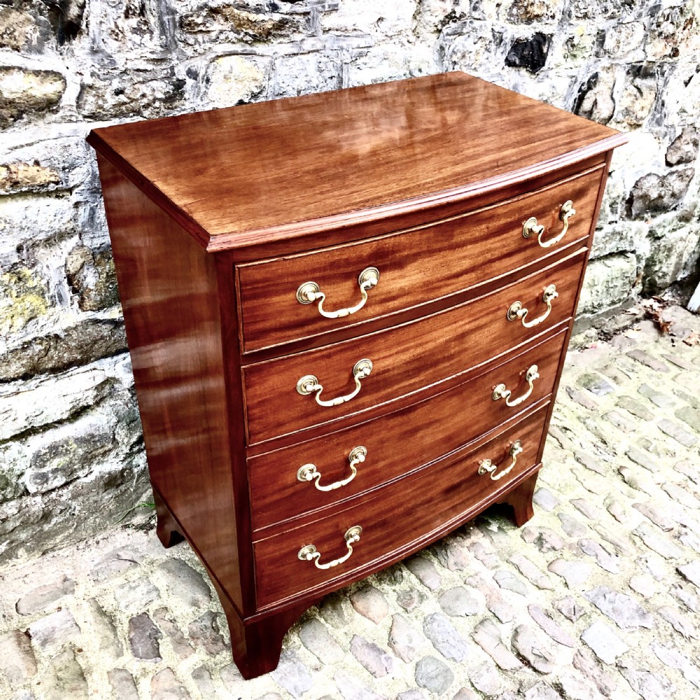 A mid-Victorian mahogany bowfront chest of drawers featuring four graduated drawers with curved fronts, brass drop handles, and bracket feet. View III