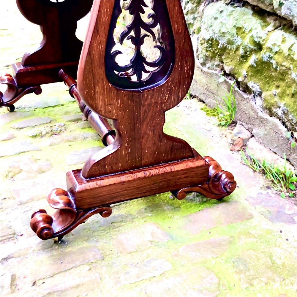 A William IV rosewood work table featuring two drawer fronts, turned knobs, keyhole escutcheons, a red fabric drop pouch, and carved end supports. View VII