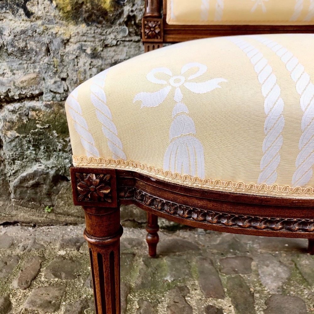 A pair of antique French Second Empire carved walnut side chairs upholstered in a cream patterned damask fabric featuring fluted legs. View VII