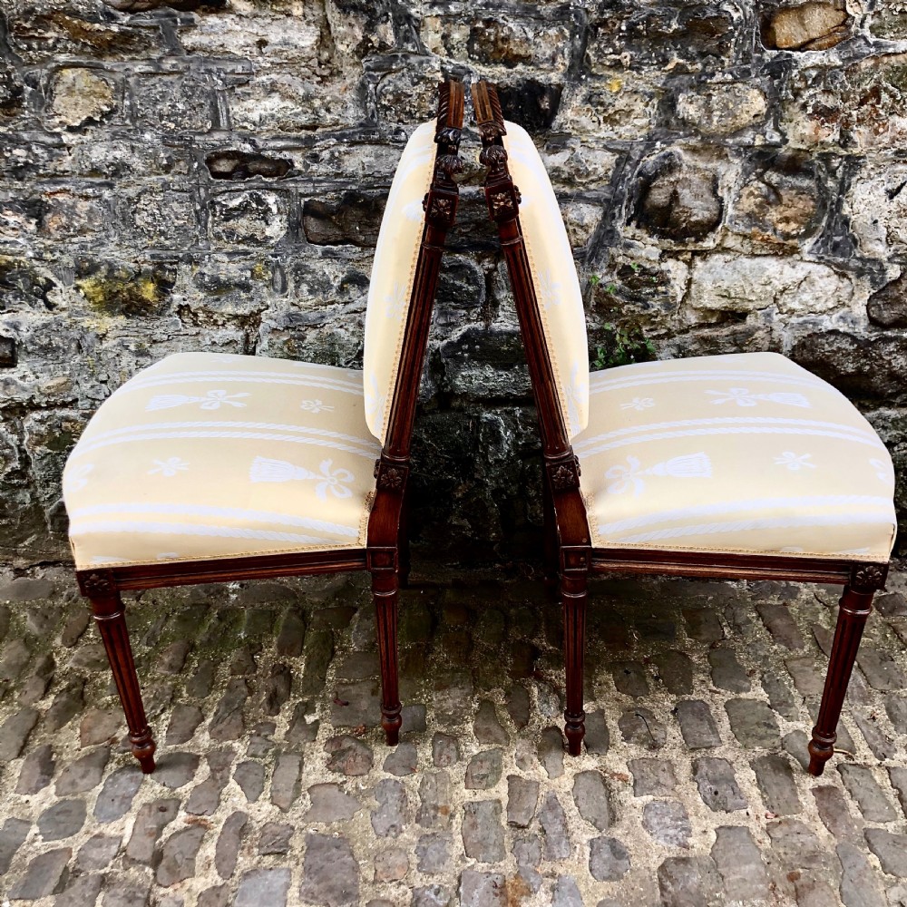 A pair of antique French Second Empire carved walnut side chairs upholstered in a cream patterned damask fabric featuring fluted legs. View VIII