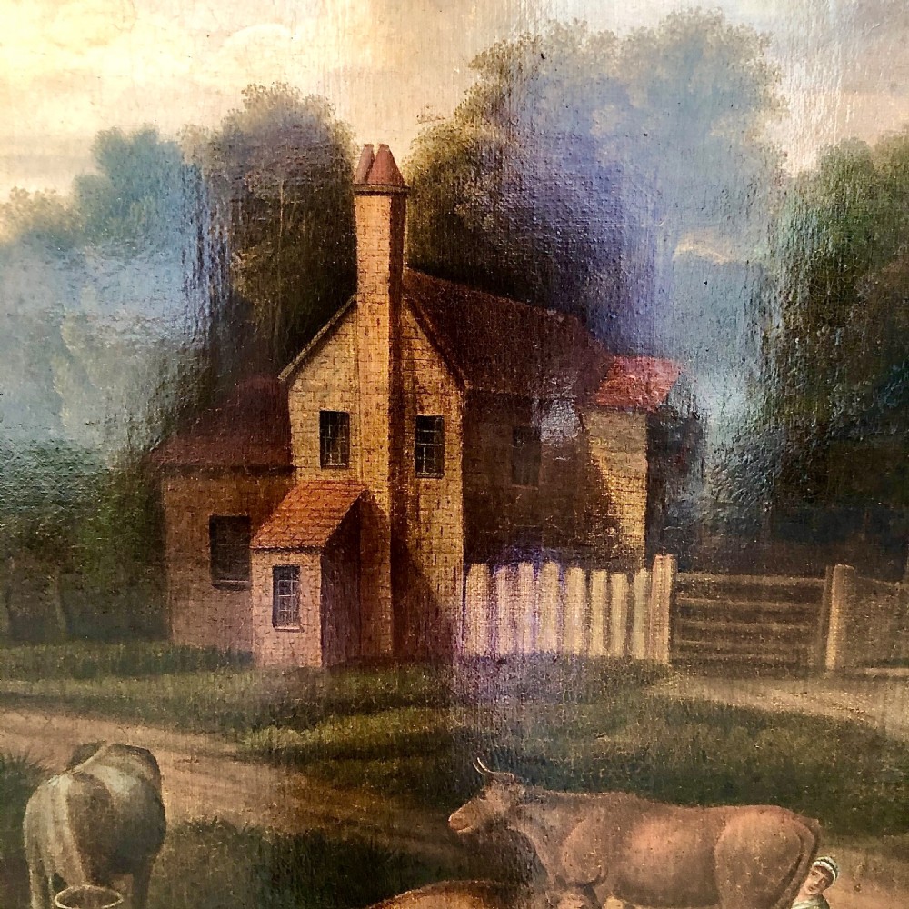 An early nineteenth-century naive oil painting depicting a pastoral scene with cattle, a stone arch bridge, and a rural cottage, housed in a wide timber frame with a gold leaf inner slip. View IV