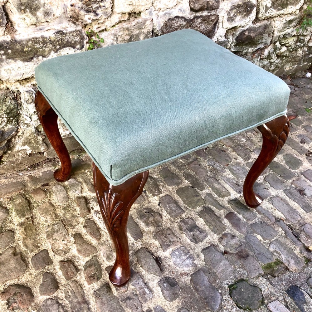 A 19th-century upholstered footstool featuring sage green fabric on a carved walnut frame with cabriole legs. View II