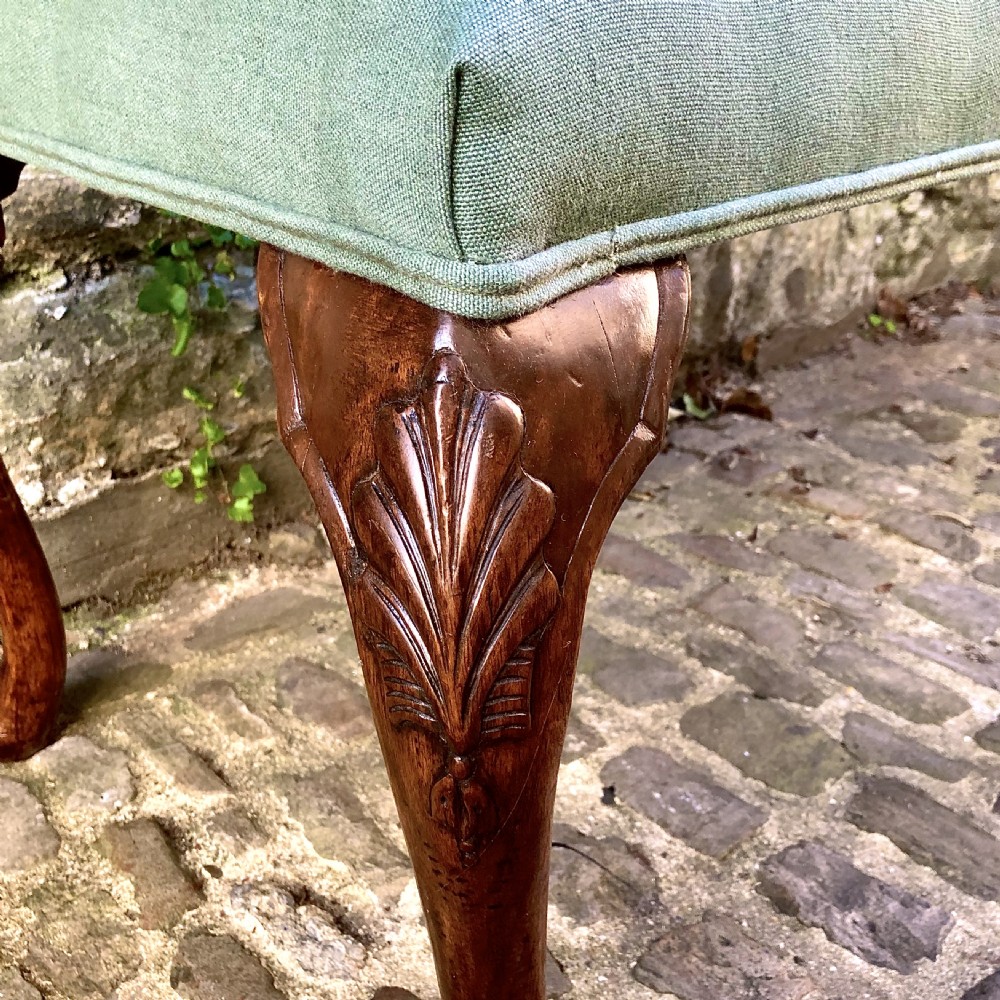 A 19th-century upholstered footstool featuring sage green fabric on a carved walnut frame with cabriole legs. View III