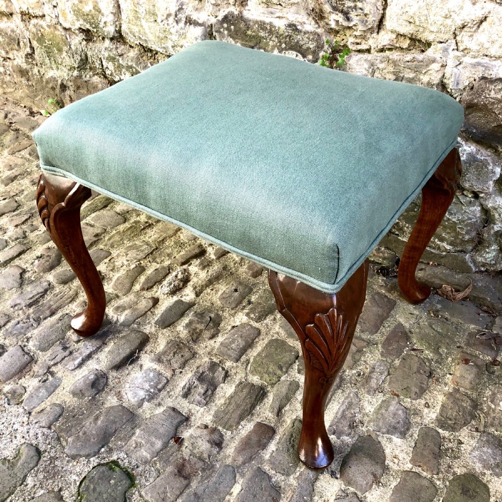 A 19th-century upholstered footstool featuring sage green fabric on a carved walnut frame with cabriole legs. View IV