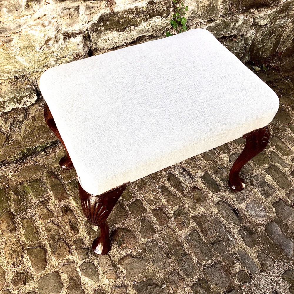 A 19th-century walnut dressing table stool featuring carved cabriole legs with shell knee detailing, brass studded trim, and a cream upholstered linen cushion. View III