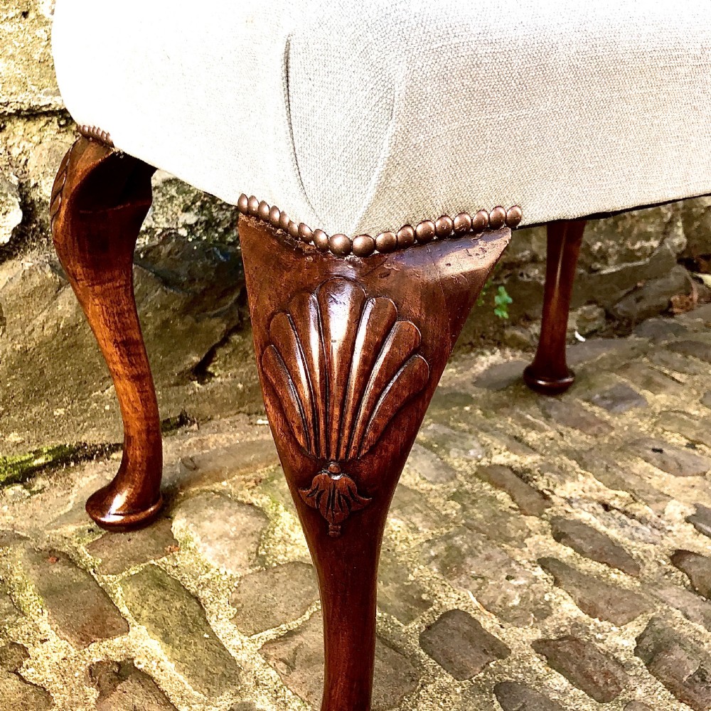 A 19th-century walnut dressing table stool featuring carved cabriole legs with shell knee detailing, brass studded trim, and a cream upholstered linen cushion. View IV