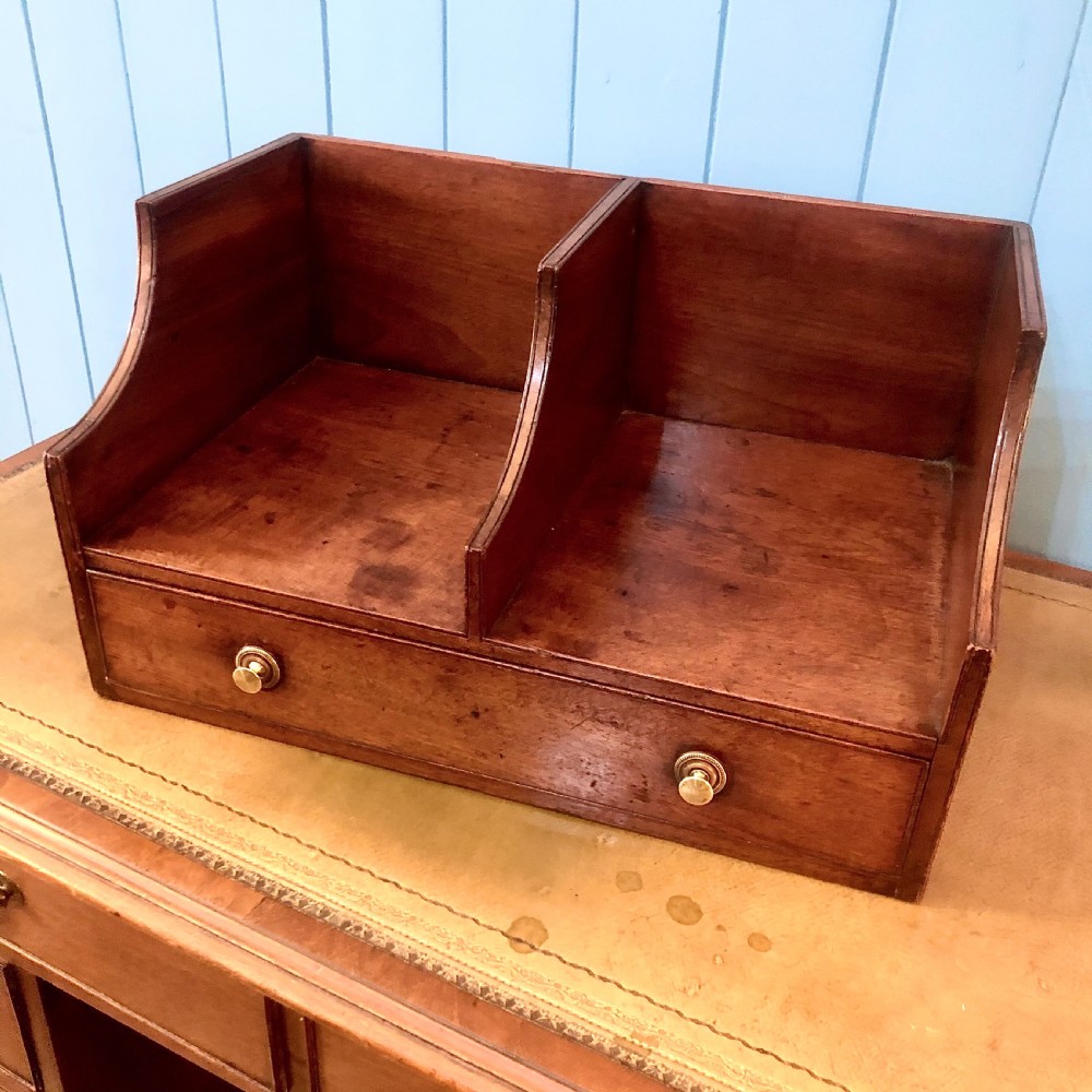 A George III mahogany book trough with two open divided compartments above a single drawer with two circular brass handles.