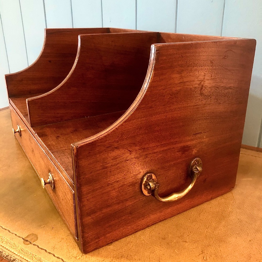 A George III mahogany book trough with two open divided compartments above a single drawer with two circular brass handles. View II
