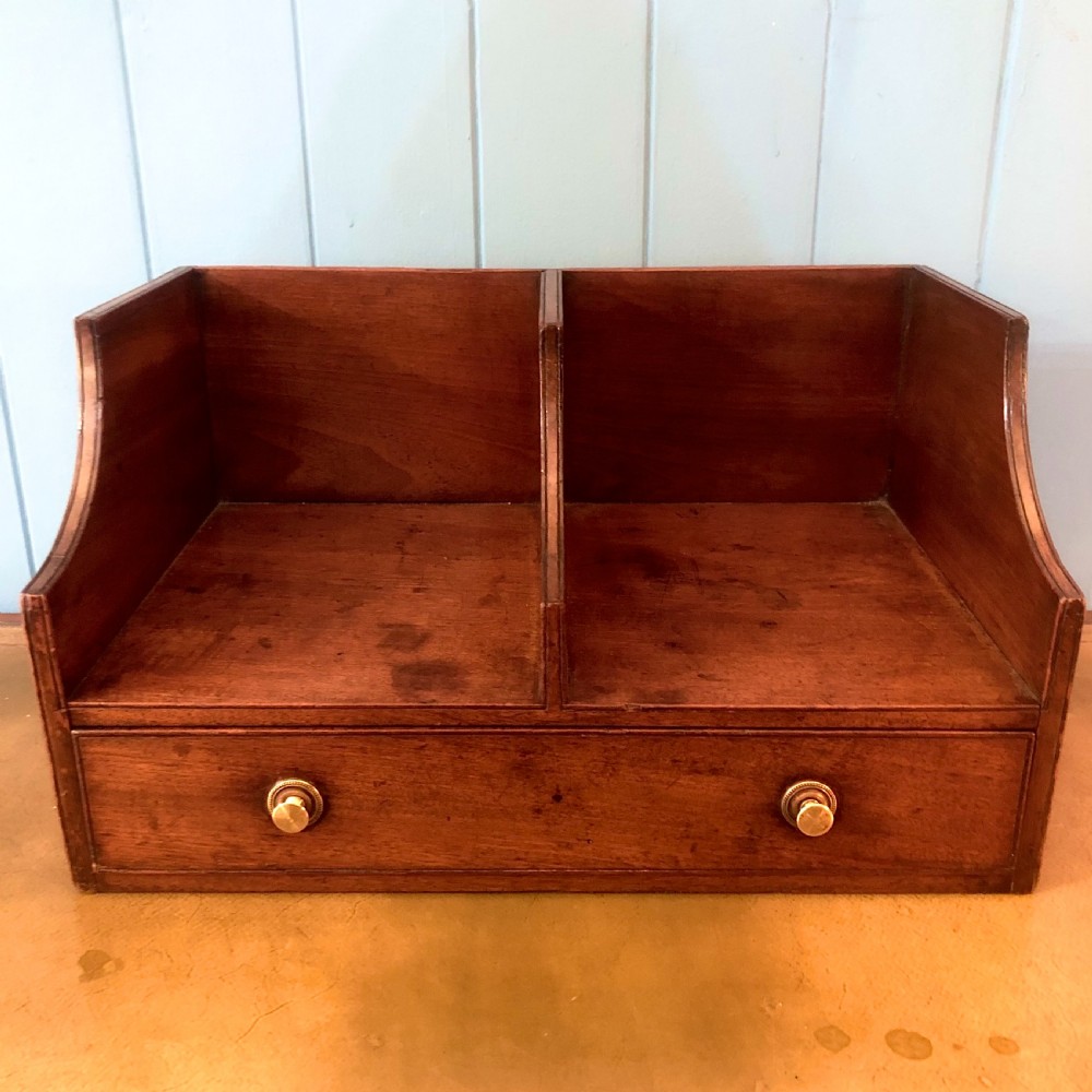 A George III mahogany book trough with two open divided compartments above a single drawer with two circular brass handles. View III