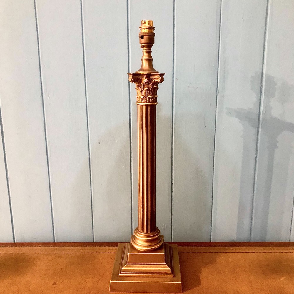 An early twentieth-century brass table lamp shaped as a fluted Corinthian column on a square stepped base.