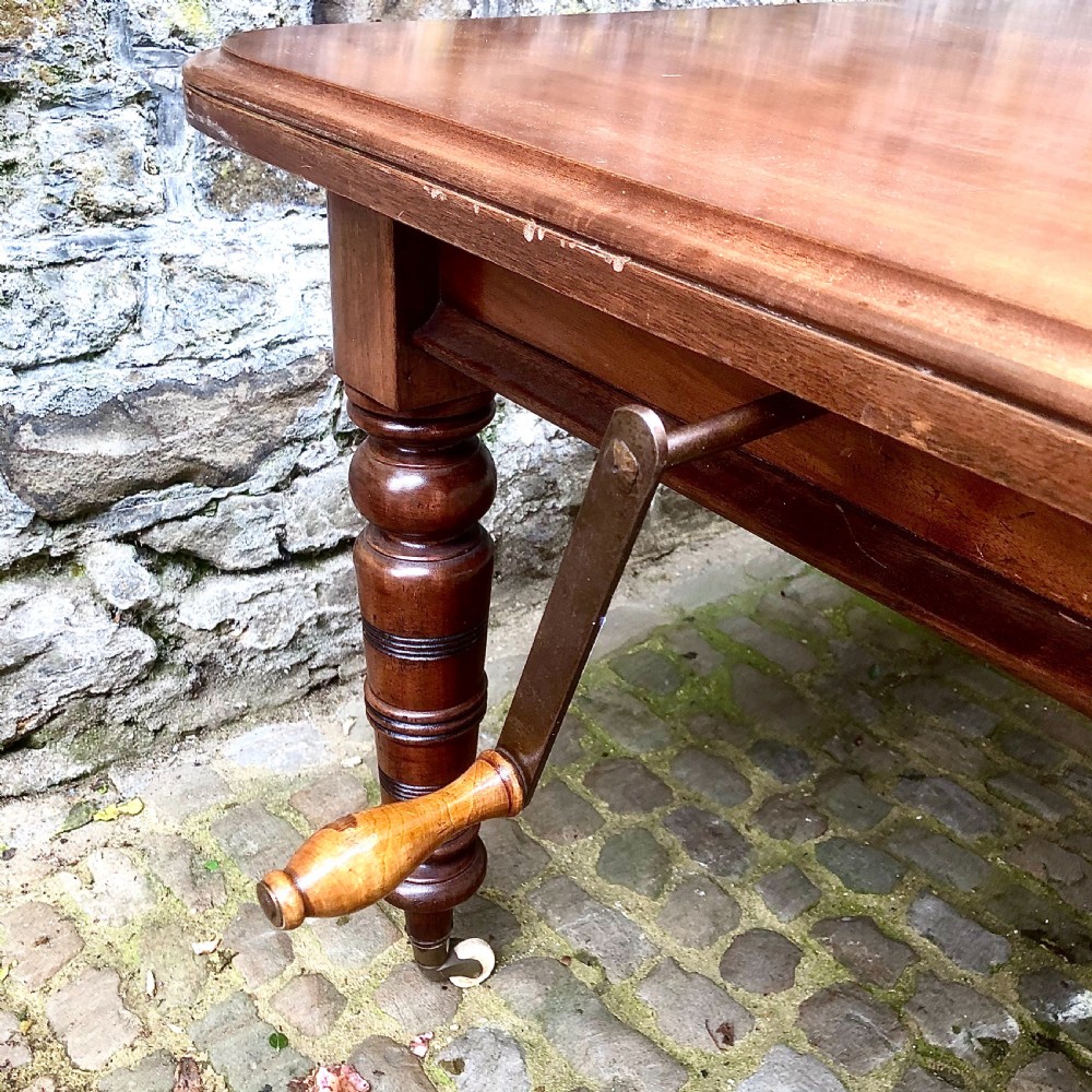 A mid Victorian mahogany extending dining table with additional leaves, turned legs, and porcelain castors. View V