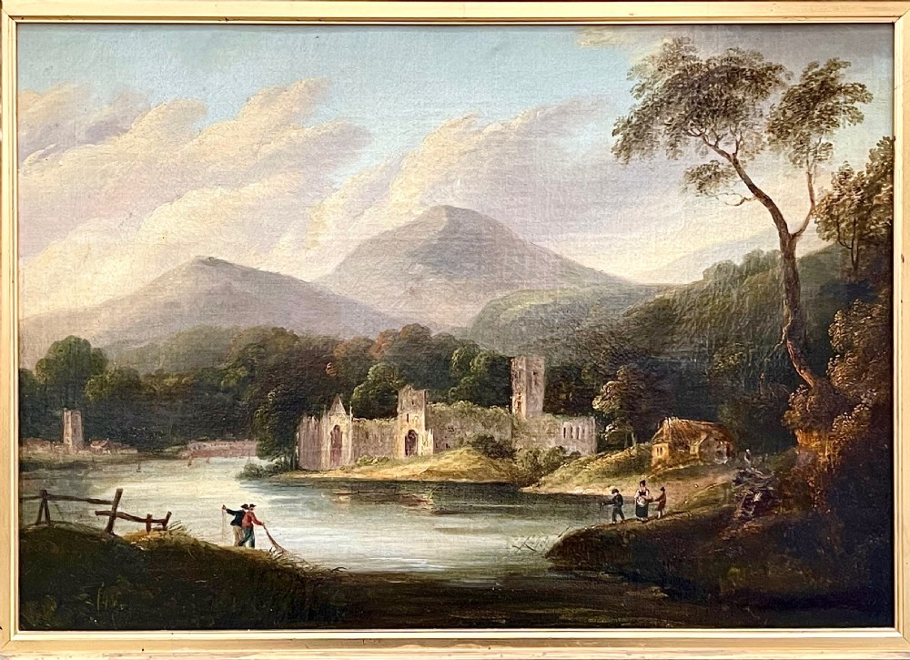 An early nineteenth-century oil painting depicting Tintern Abbey beside a river, surrounded by mountains and set within a carved gold frame. View II