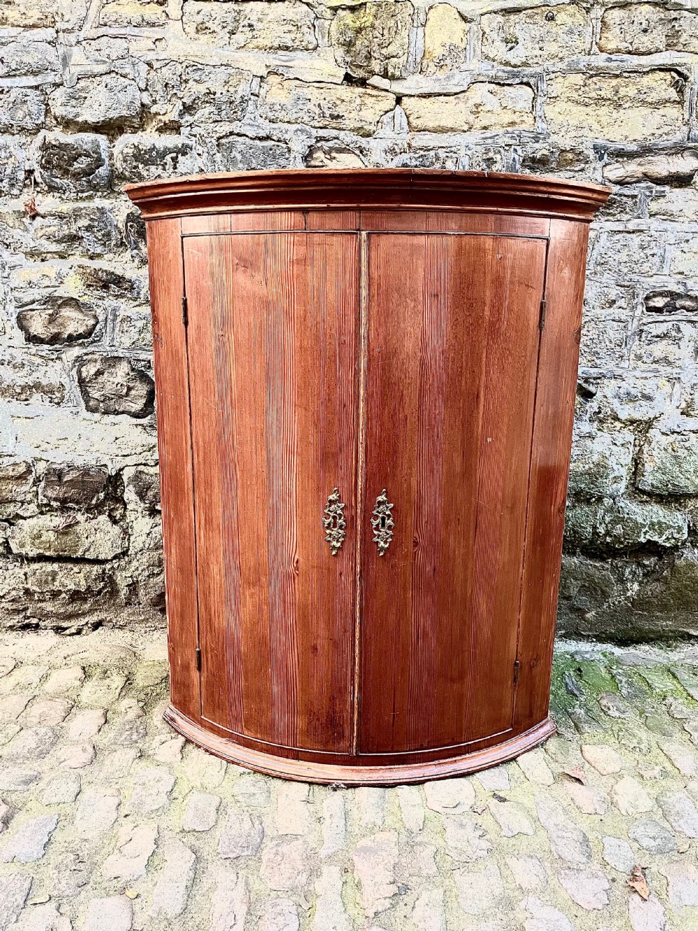 A George III pine bowfront corner cupboard 
