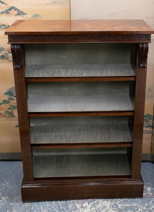 fig 1. A dark mahogany open bookcase featuring four shelves, a carved Greek key pattern along the top frieze, and carved side corbels.