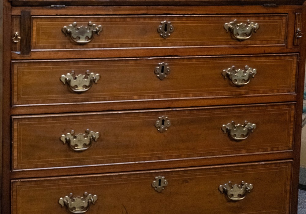 An Edwardian mahogany slant-front bureau featuring satinwood oval inlay, four graduated drawers, and brass handles. View II