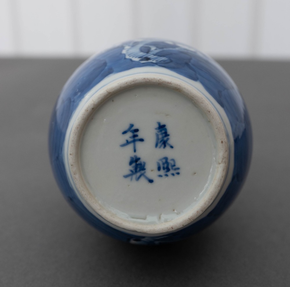A double gourd-shaped Chinese porcelain vase decorated with white prunus blossom patterns over a dark cobalt blue background. View III