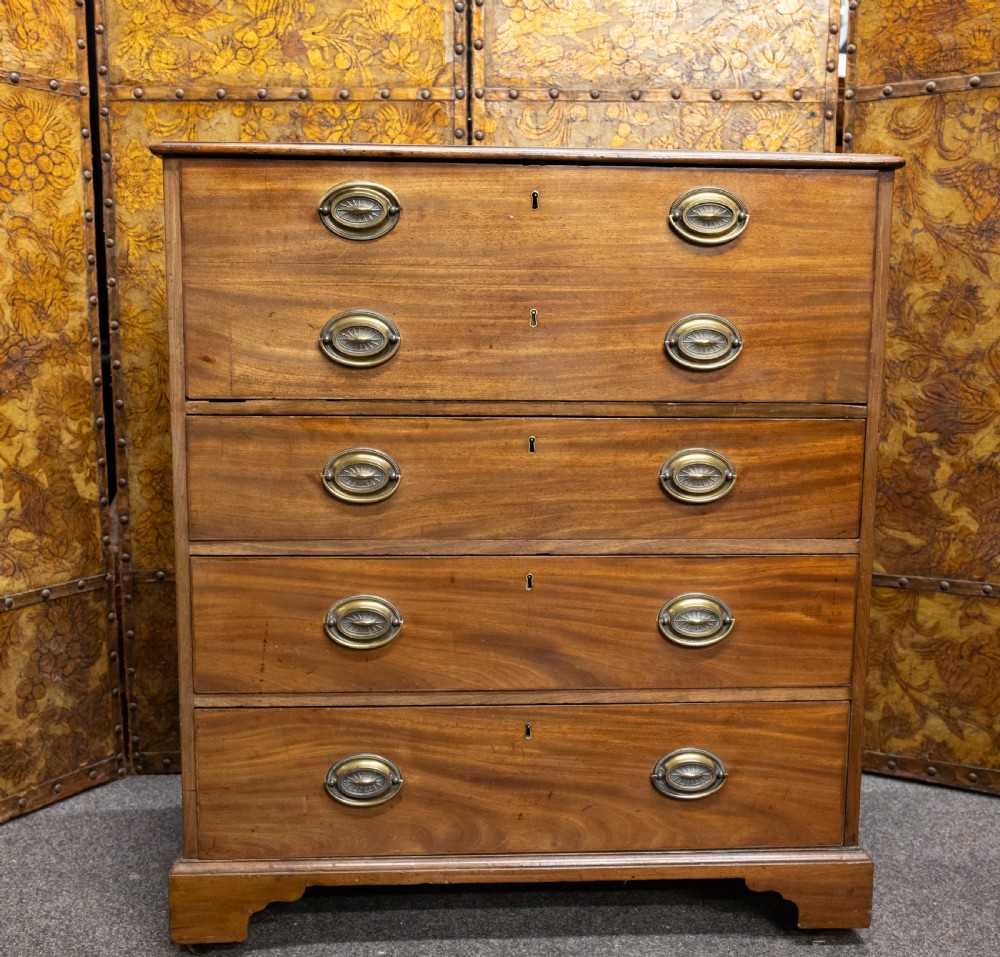 A George III mahogany secretaire chest featuring four graduated drawer fronts, oval brass backplate handles, keyhole escutcheons, and bracket feet.