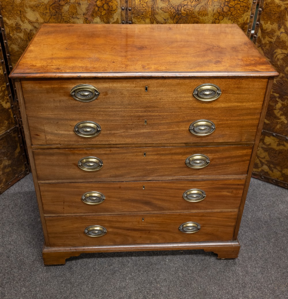 A George III mahogany secretaire chest featuring four graduated drawer fronts, oval brass backplate handles, keyhole escutcheons, and bracket feet. View II