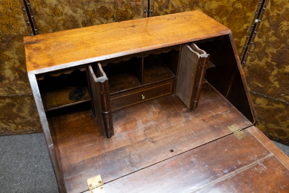 A small solid walnut slant-front bureau featuring a drop-down flap, multiple drawers with brass handles, and cabriole legs. View IV