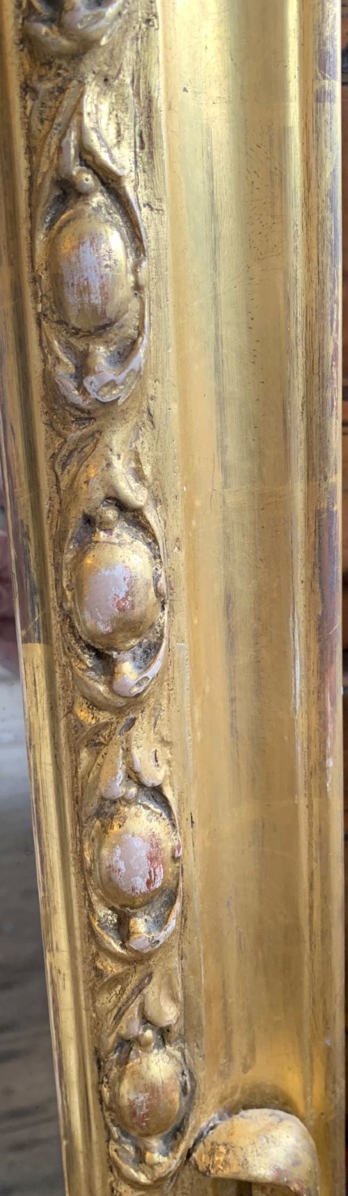 An early Victorian gold giltwood overmantel mirror featuring an arched top, beaded border moulding, and foliate scroll details at the base. View II
