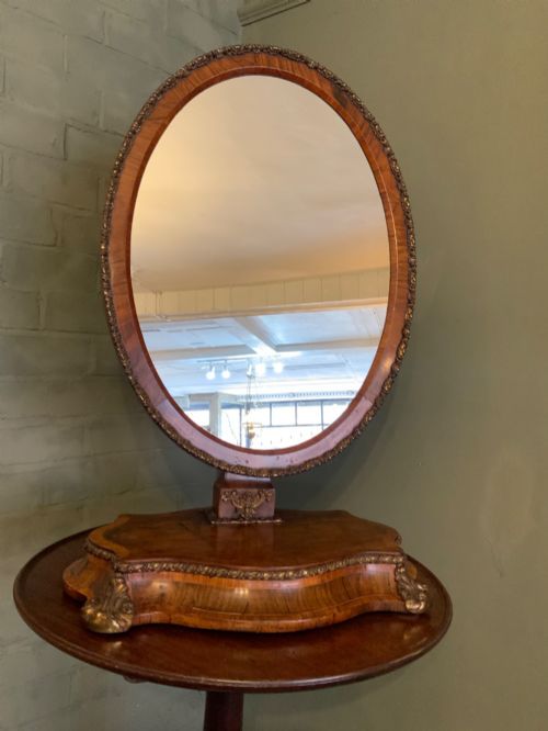 A Large Oval Walnut and Ormolu Toilet Mirror.