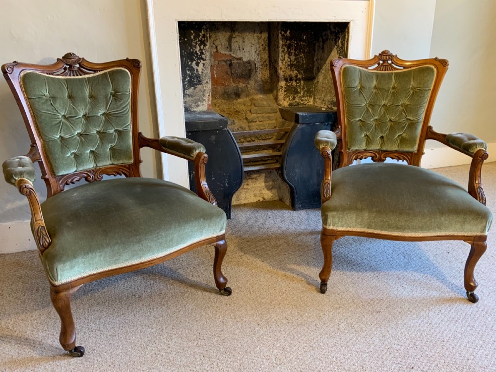 A pair of Victorian walnut arm chairs