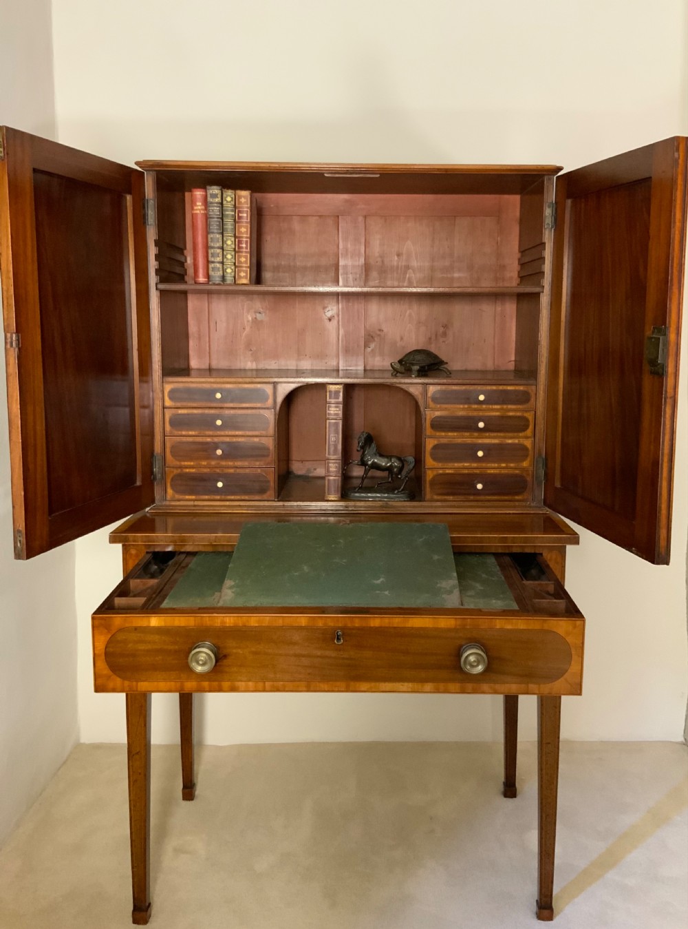 Georgian mahogany writing desk featuring a upper cabinet with oval inlaid panels above a single drawer and tapered square legs. View II