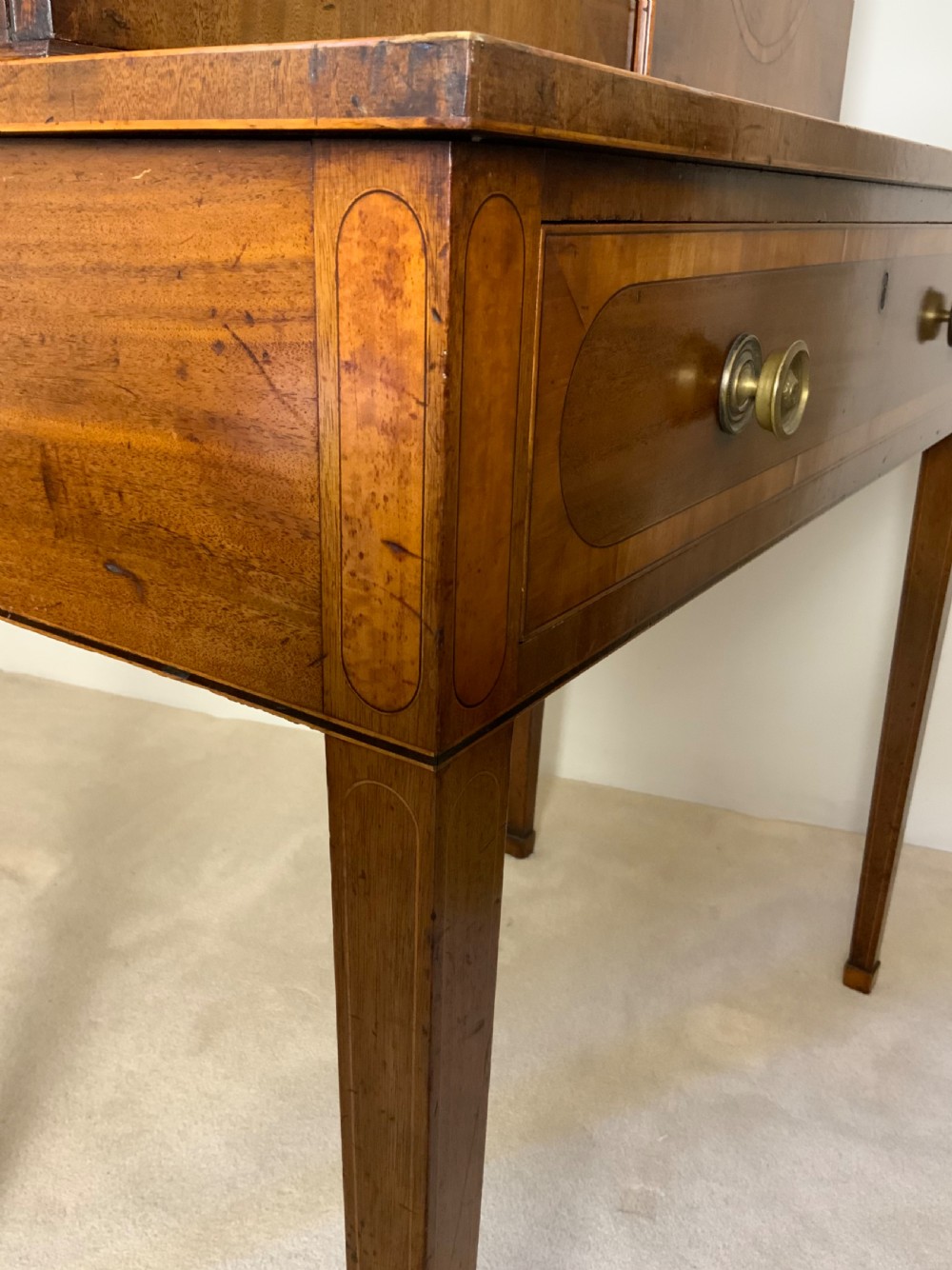 Georgian mahogany writing desk featuring a upper cabinet with oval inlaid panels above a single drawer and tapered square legs. View VI