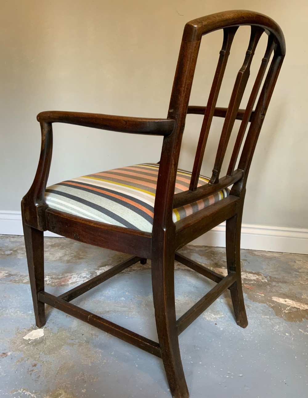 A dark mahogany Georgian open armchair with slender vertical back splats, sweeping armrests, and a multi-coloured striped upholstered seat. View II