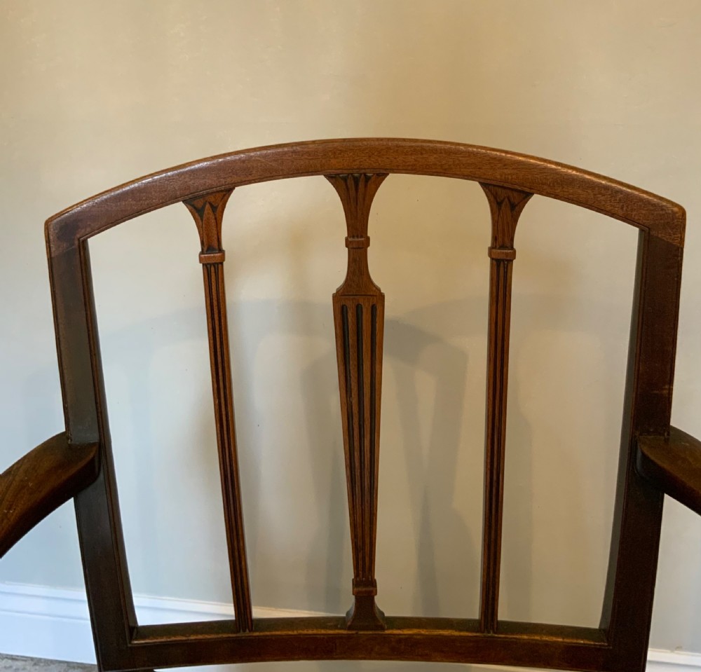 A dark mahogany Georgian open armchair with slender vertical back splats, sweeping armrests, and a multi-coloured striped upholstered seat. View VI