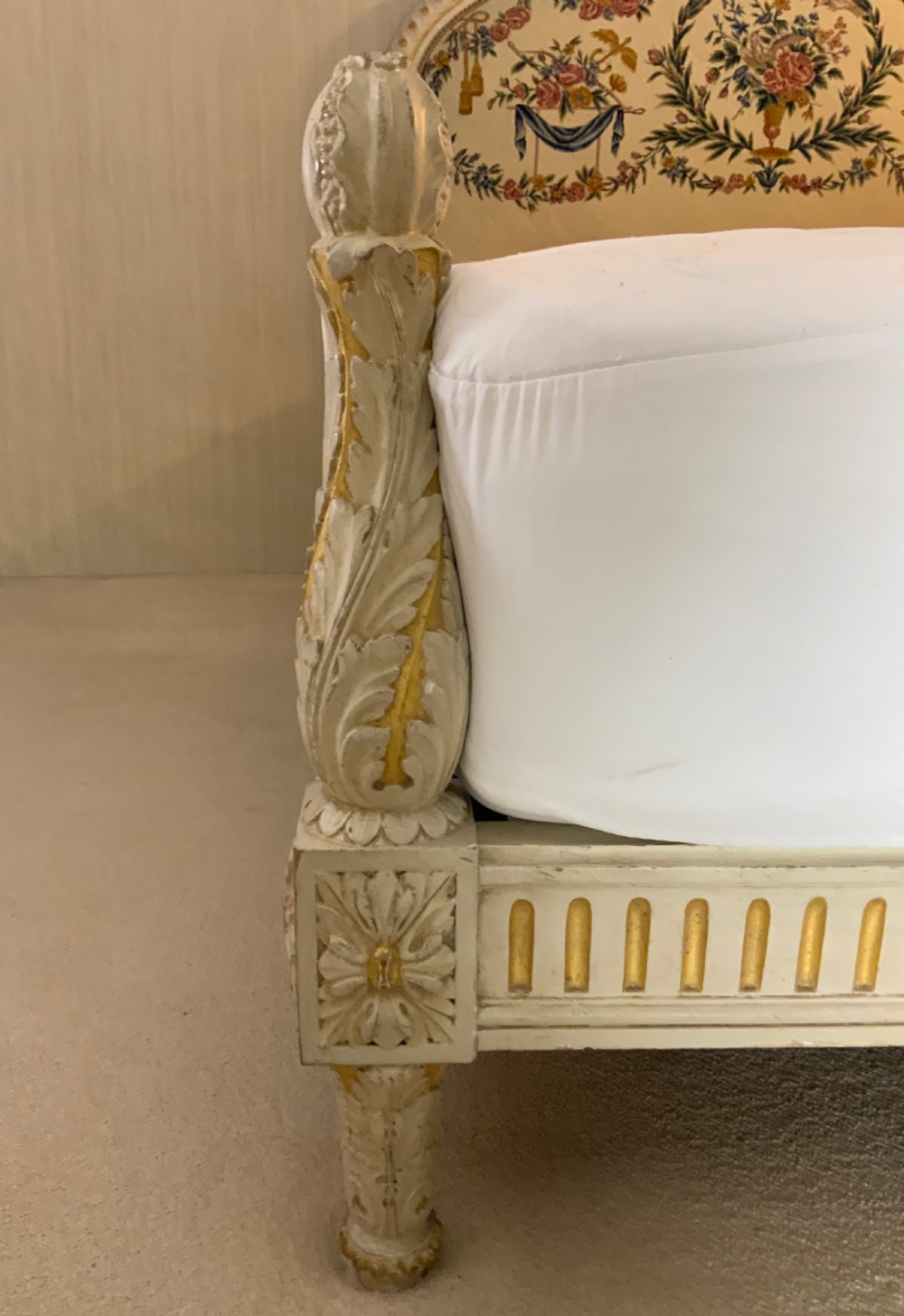 A carved cream painted and parcel gilt five-foot bed frame featuring a arched floral tapestry upholstered headboard and fluted footboard. View III