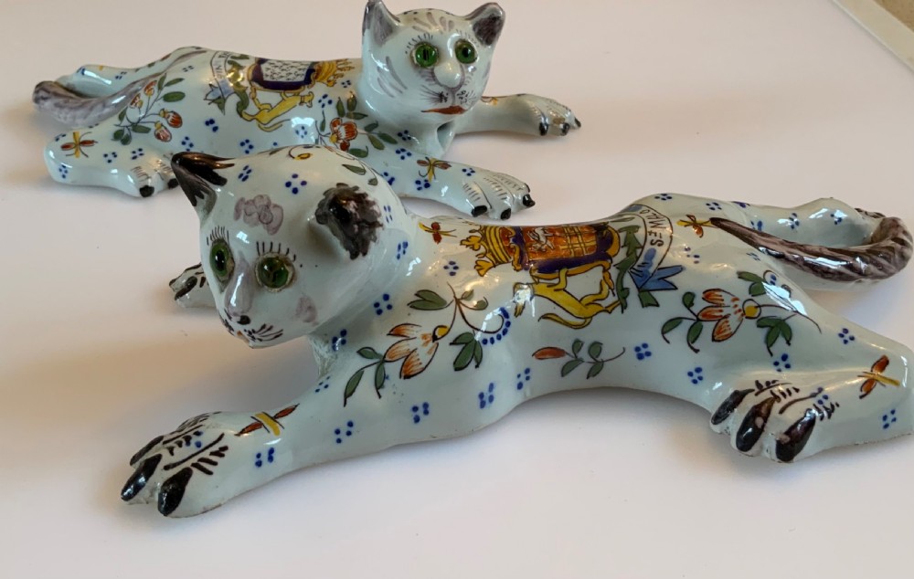 A pair of hand-painted tin-glazed ceramic cat wall pockets styled in recumbent poses with heraldic coat of arms motifs and green glass eyes. View II