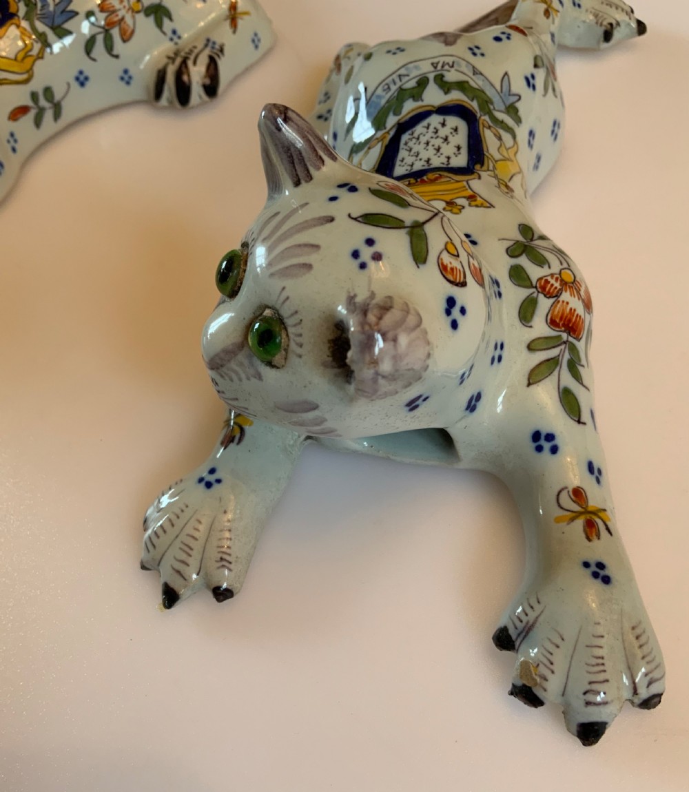 A pair of hand-painted tin-glazed ceramic cat wall pockets styled in recumbent poses with heraldic coat of arms motifs and green glass eyes. View III