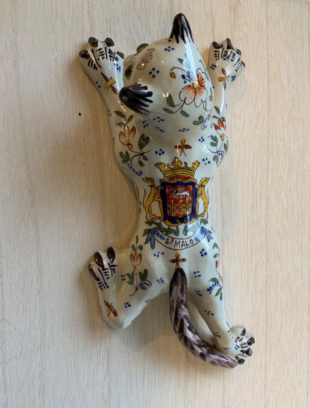 A pair of hand-painted tin-glazed ceramic cat wall pockets styled in recumbent poses with heraldic coat of arms motifs and green glass eyes. View IV