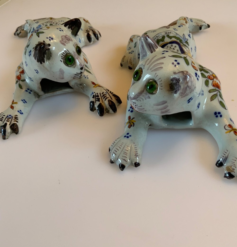 A pair of hand-painted tin-glazed ceramic cat wall pockets styled in recumbent poses with heraldic coat of arms motifs and green glass eyes. View V