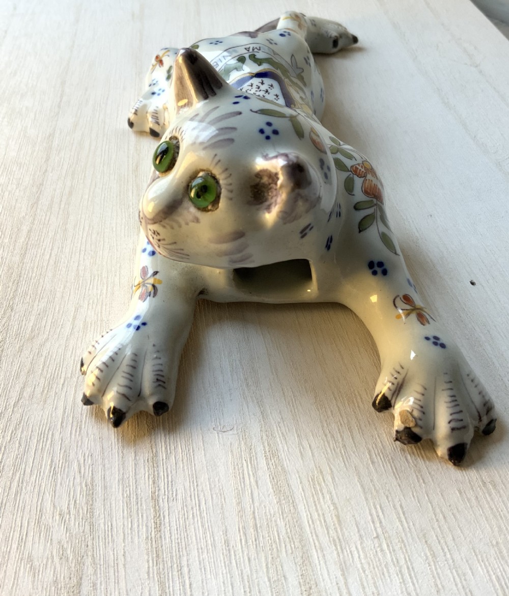 A pair of hand-painted tin-glazed ceramic cat wall pockets styled in recumbent poses with heraldic coat of arms motifs and green glass eyes. View VI